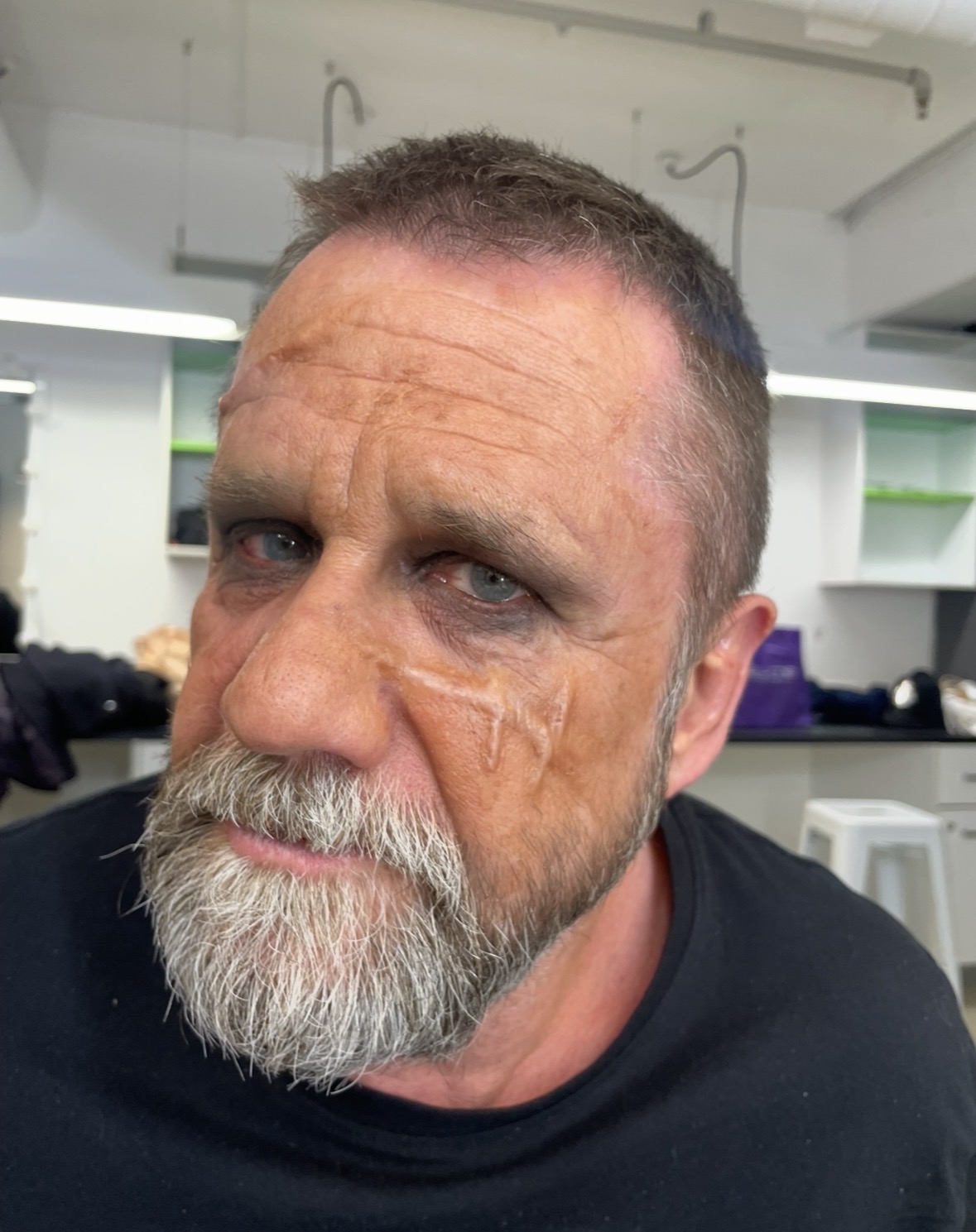 Aged character makeup — subtle scar work and grey beard