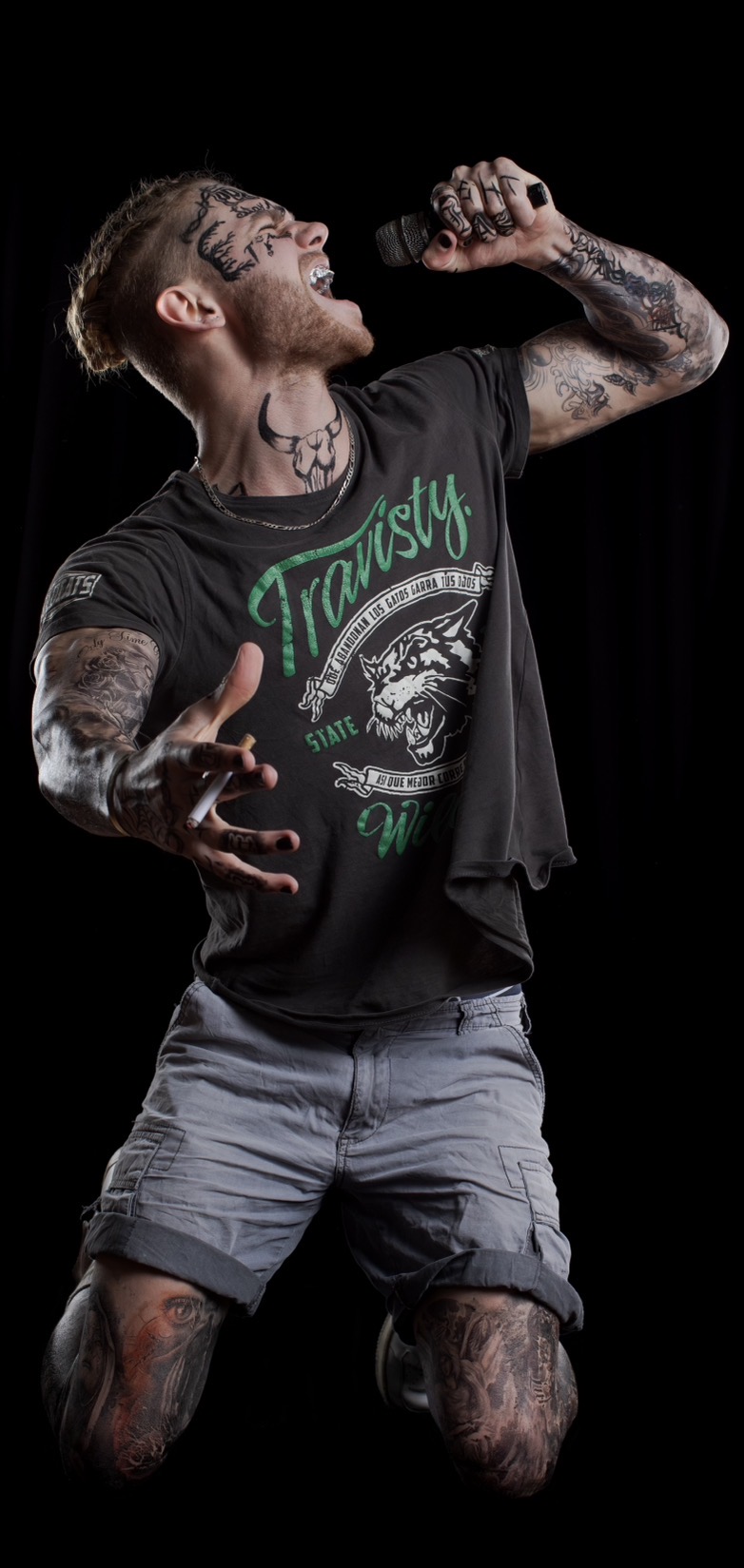 Tattooed rock vocalist mid-performance, microphone in hand