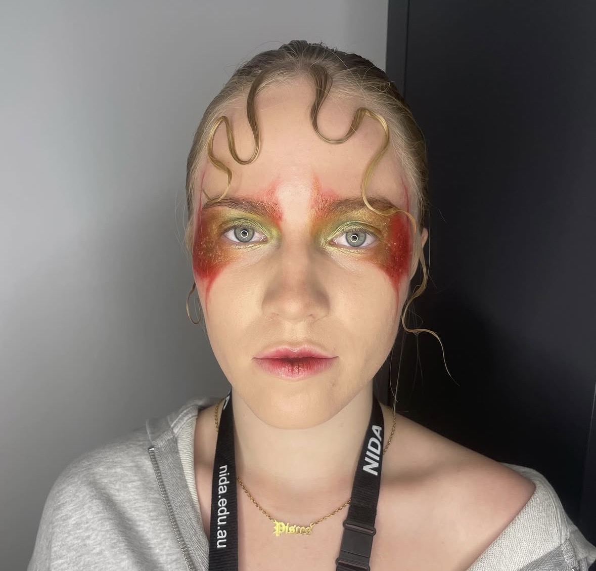 Avant-garde beauty — orange and green graphic eye with sculpted hair