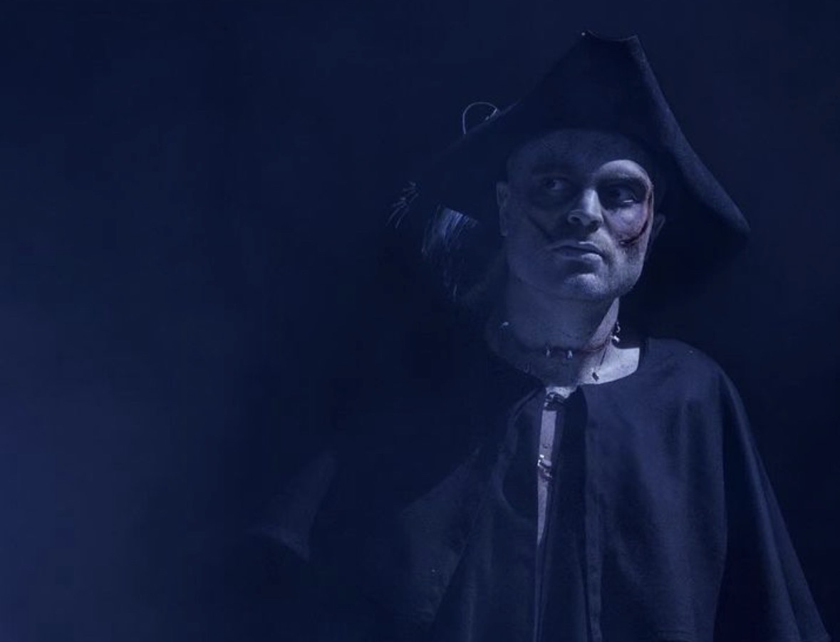 Shadowy pirate in tricorn hat lit in deep blue